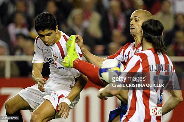 Atletico de Madrid's Mariano Pernía vies for the ball with Sevilla's Renato Dirnei during their Spanish league football match at Sanchez Pizjuan...