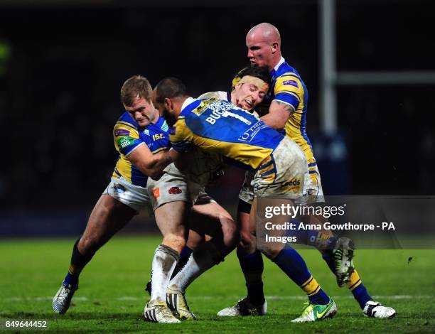 Salford City Reds' Andrew Dixon is tackled by Leeds Rhinos' Paul McShane , Jamie Jones-Buchanan and Richard Moore during the Super League match at...