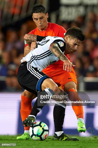 Santi Mina of Valencia competes for the ball with Federico Ricca of Malaga during the La Liga match between Valencia and Malaga at Estadio Mestalla...