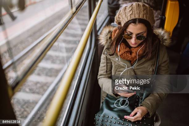 woman listening music in tram - young woman trolley stock pictures, royalty-free photos & images