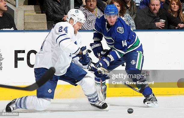 Alex Burrows of the Vancouver Canucks battles for the puck with Jonas Frogren the Toronto Maple Leafs during their NHL game at the Air Canada Centre...