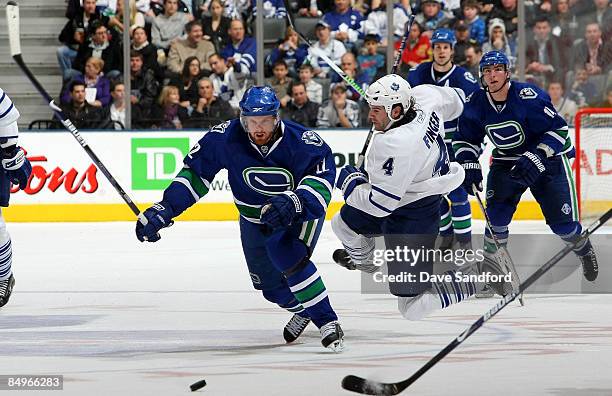 Jeff Finger of the Toronto Maple Leafs misses a hit on Daniel Sedin of the Vancouver Canucks during their NHL game at the Air Canada Centre February...