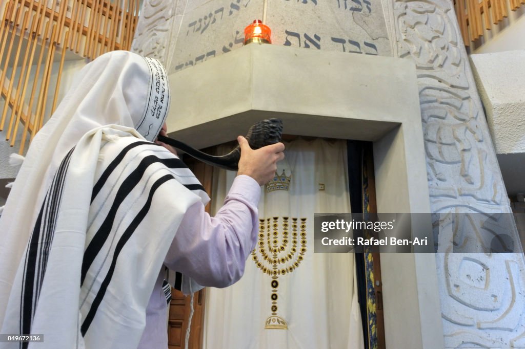 Jewish Rabbi blows Shofar in a synagogue