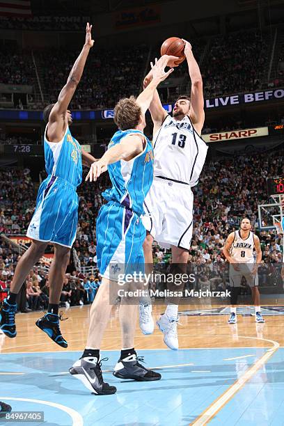 Mehmet Okur of the Utah Jazz goes up for the shot over Rasual Butler and Sean Marks of the New Orleans Hornets at EnergySolutions Arena on February...