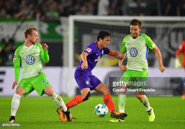 Thomas Delaney of Bremen is challenged by Maximilian Arnold and Ignacio Camacho of Wolfsburg during the Bundesliga match between VfL Wolfsburg and SV...