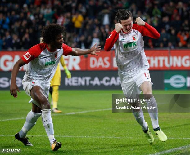 Michael Gregoritsch of Augsburg celebrates after he scored his teams first goal to make it 1:0 with Caiuby of Augsburg during the Bundesliga match...