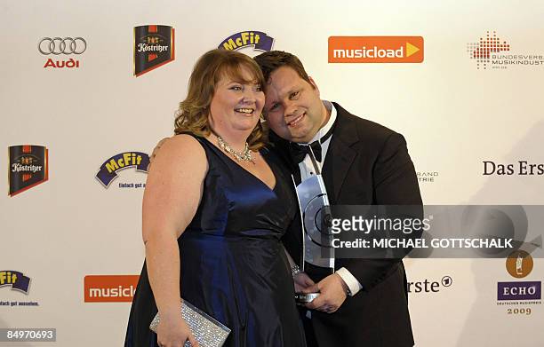 British tenor Paul Potts poses with his wife his wife Julie-Ann as he presents his "Echo" trophy he was awarded in the "Best Artist International "...
