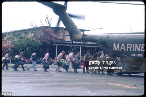 Marines guard the evacuation of civilians at Tan Son Nhut airbase in Vietnam while under Viet Cong fire, during the fall of Saigon, April 15, 1975.