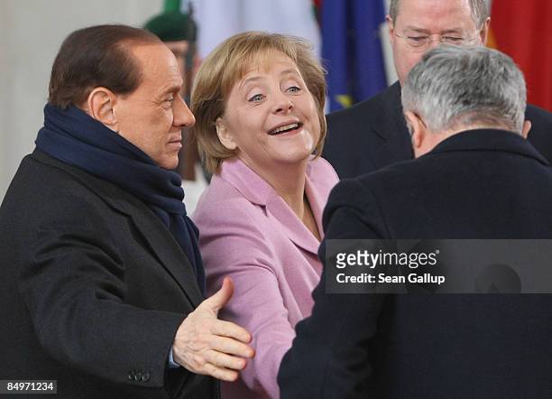 German Chancellor Angela Merkel greets Italian Finance Minister Giulio Tremonti as Italian Prime Minister Silvio Berlusconi looks on upon their...