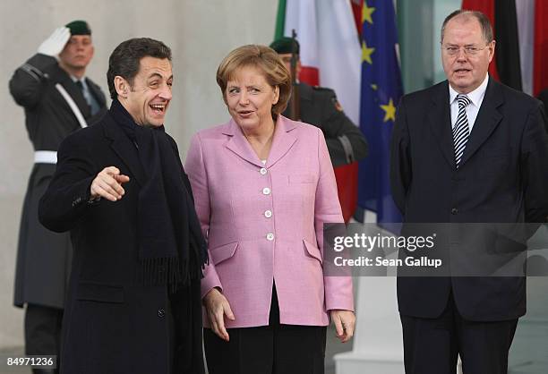 German Chancellor Angela Merkel greets French President Nicolas Sarkozy upon his arrival for a meeting of European Union leaders at the Chancellery...