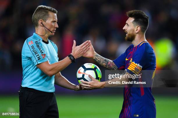 The referee Alejandro Jose Hernandez Hernandez gives the ball to Lionel Messi of FC Barcelona atg the end of the La Liga match between Barcelona and...