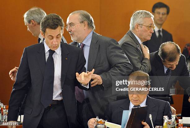 French President Nicolas Sarkozy greets Spanish Finance Minister Pedro Solbes behind Italian Prime Minister Silvio Berlusconi during a G20...