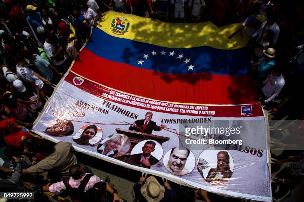 Attendees hold a sign depicting the images of U.S. President Donald Trump and opposition leaders during a rally in support of Nicolas Maduro,...