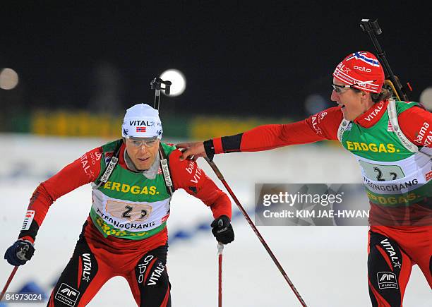 Norway's Lars Berger tags teammate Halvard Hanevold during the men's relay race at the IBU World Biathlon Championships in Pyeongchang, east of Seoul...
