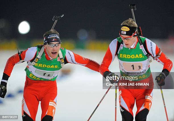 Austria's Simon Eder tags teammate Dominik Landertinger during the men's relay race at the IBU World Biathlon Championships in Pyeongchang, east of...