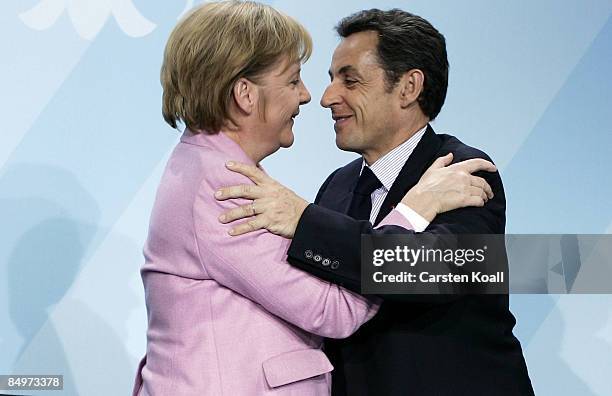 German Chancellor Angela Merkel hugs French President Nicolas Sarkozy upon a press conference after a meeting of European Union leaders at the...