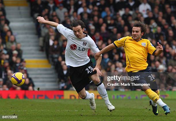 Simon Davies of Fulham holds off Felipe Teixeira of West Bromwich Albion during the Barclays Premier League match between Fulham and West Bromwich...