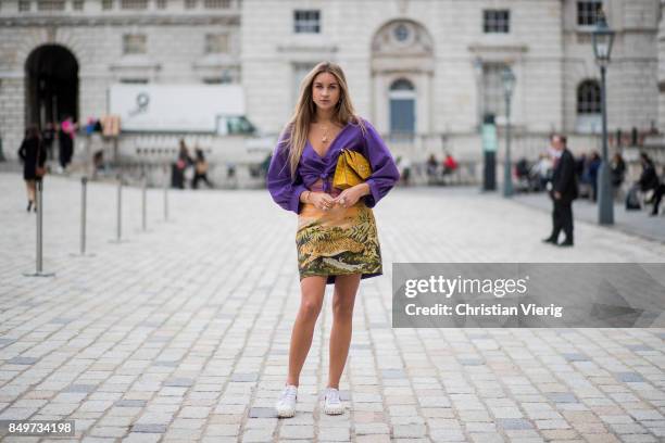 Nina Suess wearing purple Marc Cain blouse, a Marc Cain skirt with a tiger jungle print, yellow Marc Cain bag during London Fashion Week September...