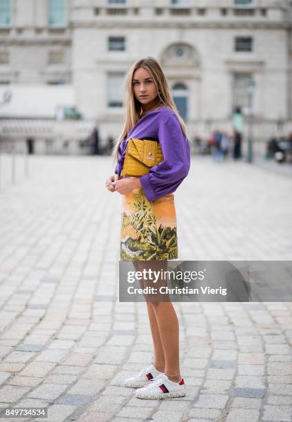 Nina Suess wearing purple Marc Cain blouse, a Marc Cain skirt with a tiger jungle print, yellow Marc Cain bag during London Fashion Week September...