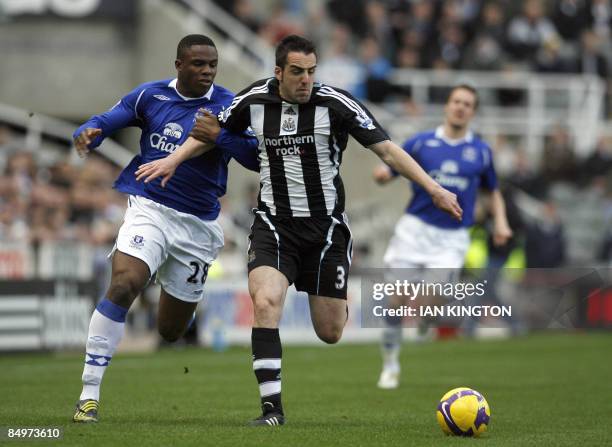 Newcastle United's Spanish footballer Jose Enrique defends against Everton's Nigerian player Victor Anichebe during their Premier League football...