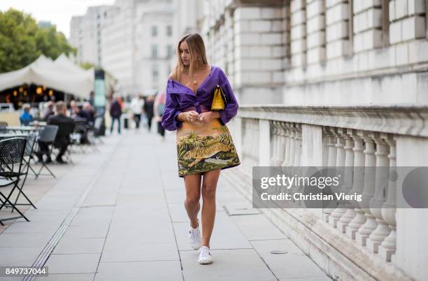 Nina Suess wearing purple Marc Cain blouse, a Marc Cain skirt with a tiger jungle print, yellow Marc Cain bag during London Fashion Week September...