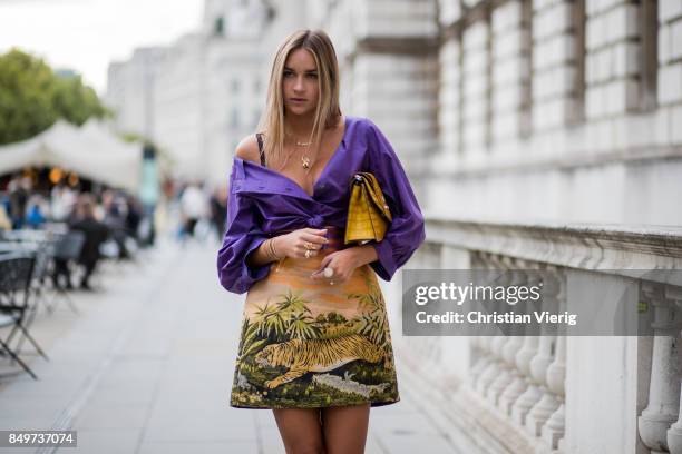 Nina Suess wearing purple Marc Cain blouse, a Marc Cain skirt with a tiger jungle print, yellow Marc Cain bag during London Fashion Week September...