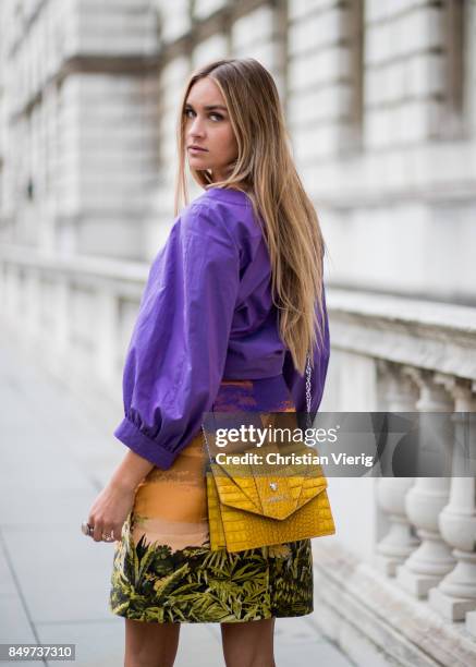 Nina Suess wearing purple Marc Cain blouse, a Marc Cain skirt with a tiger jungle print, yellow Marc Cain bag during London Fashion Week September...