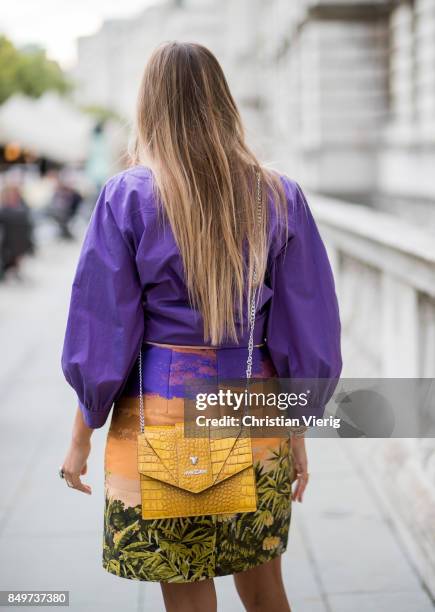 Nina Suess wearing purple Marc Cain blouse, a Marc Cain skirt with a tiger jungle print, yellow Marc Cain bag during London Fashion Week September...