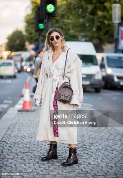 Aylin Koenig wearing white trench, Louis Vuitton backpack outside Tommy Hilfiger during London Fashion Week September 2017 on September 19, 2017 in...