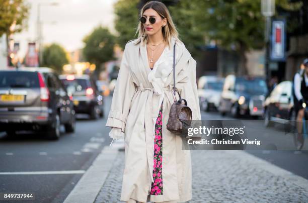 Aylin Koenig wearing white trench, Louis Vuitton backpack outside Tommy Hilfiger during London Fashion Week September 2017 on September 19, 2017 in...