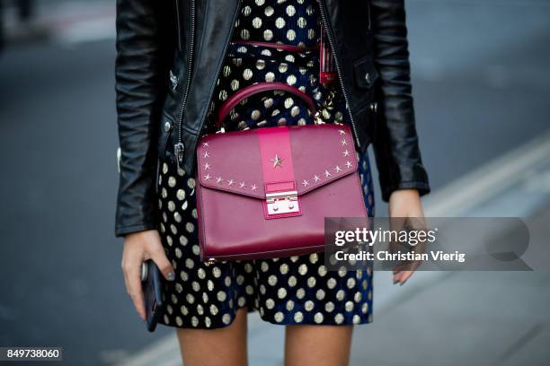 Guest wearing red bag outside Tommy Hilfiger during London Fashion Week September 2017 on September 19, 2017 in London, England.