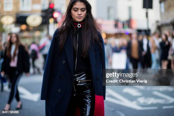 Guest wearing navy blue cape outside Tommy Hilfiger during London Fashion Week September 2017 on September 19, 2017 in London, England.