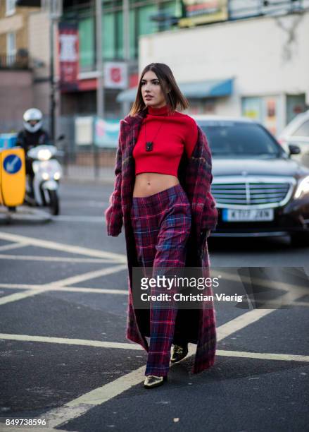 Patricia Manfield wearing checked pants and coat, red cropped top outside Tommy Hilfiger during London Fashion Week September 2017 on September 19,...