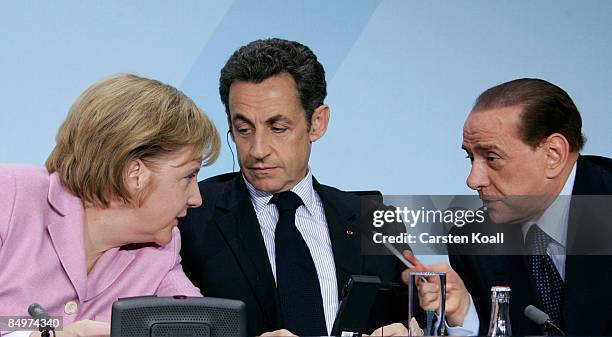 German Chancellor Angela Merkel chats with French President Nicolas Sarkozy and Italian Prime Minister Silvio Berlusconi during a press conference...