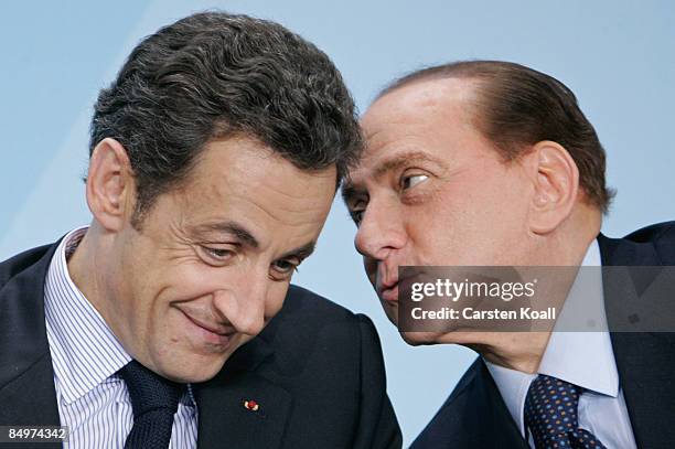 French President Nicolas Sarkozy and Italian Prime Minister Silvio Berlusconi chat during a press conference following a meeting of European Union...