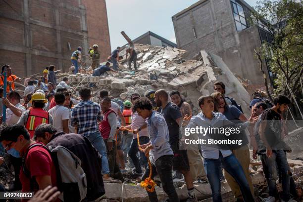 People remove debris from a collapsed building following an earthquake in the neighborhood of Condesa, Mexico City, Mexico, on Tuesday, Sept. 19,...