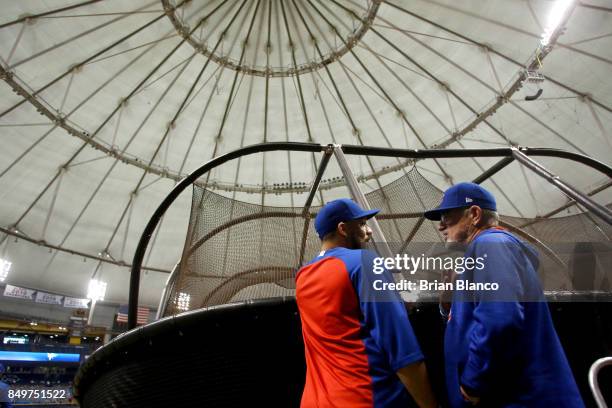 Manager Joe Maddon of the Chicago Cubs speaks with catcher Rene Rivera on the field before the start of a game against the Tampa Bay Rays on...