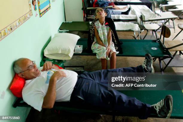 Andrea Rivera and her husband Abigail Acevedo rest at a hurricane shelter as Hurricane Maria approaches Puerto Rico in Fajardo on September 19, 2017....