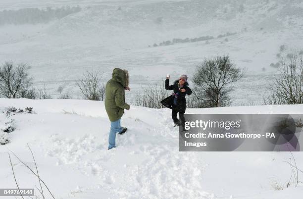 Gary Roberts and Steph Scattergood have a snowball fight at the Hole of Horcum on the North Yorkshire Moors as snow showers continue to fall over...