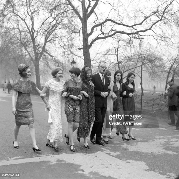 The Duke of Bedford walks arm-in-arm with some of the models in the Berkeley Debutante Dress Show. From left: Sally Stainforth, Eugenie Vivian,...