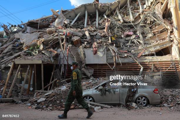 Military police guards a building knocked down by a magnitude 7.1 earthquake that jolted central Mexico damaging buildings, knocking out power and...