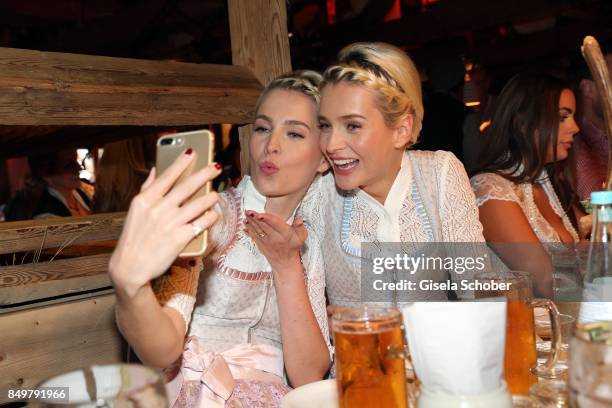 Julia Meise and her twin sister Nina Meise wearing a dirndl by 'Alpenherz' during the "Alpenherz Wies'n" as part of the Oktoberfest at Theresienwiese...