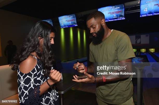 Player Justin Hardy signs autograph for fan at the launch of the $500K fundraising campaign for the American Cancer Society on September 19, 2017 at...