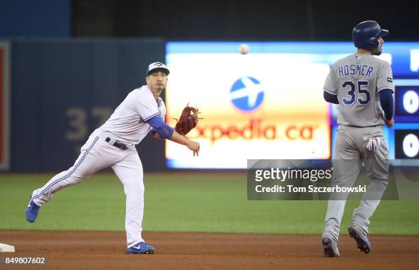 Darwin Barney of the Toronto Blue Jays turns a double play in the fourth inning during MLB game action as Eric Hosmer of the Kansas City Royals peels...