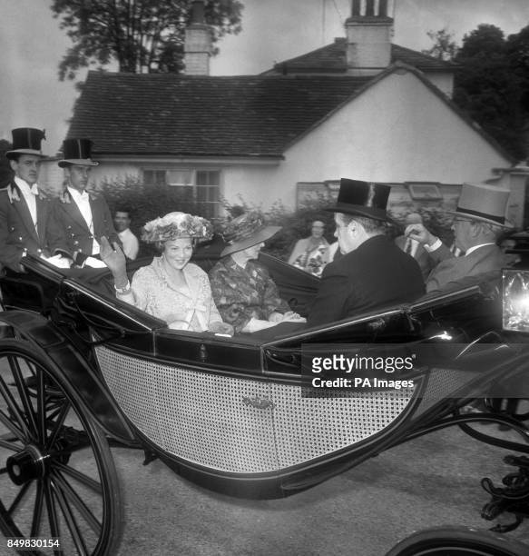 Princess Beatrix of the Netherlands, wearing a wide-brimmed flowered hat, smiles and waves as she drives in the Royal carriage procession up the...