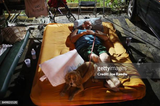 Estaban Ramos and his dog Mia sleep in the parking lot of the apartment building where he lived before being evacuated when Hurricane Irma passed...