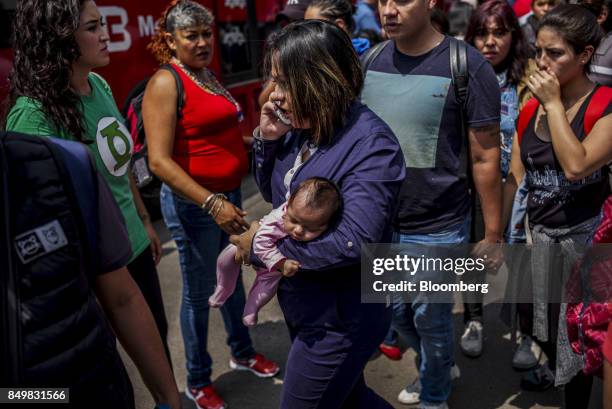 Woman carries a baby along Avenida Insurgentes following an earthquake in Mexico City, Mexico, on Tuesday, Sept. 19, 2017. A powerful 7.2 magnitude...