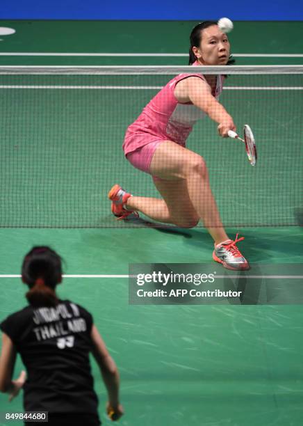 Beiwen Zhang of the US hits a return to Nitchaon Jindapol of Thailand during their women's singles first round match at Japan Open Badminton...