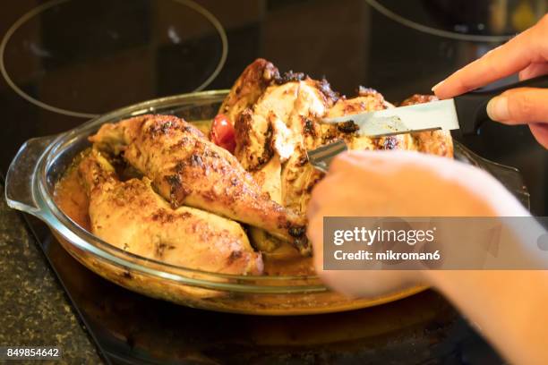 hands cutting roast chicken. homemade roasted chicken whit spices for dinner - hoja de aluminio fotografías e imágenes de stock