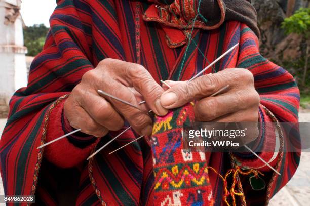 An artisan weaves a hat on the streets of Chinchero in the Sacred Valley near Cuzco. Chinchero is a small Andean Indian village located high up on...